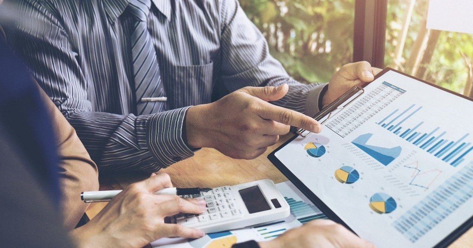 A person reviewing financial charts and figures at a desk